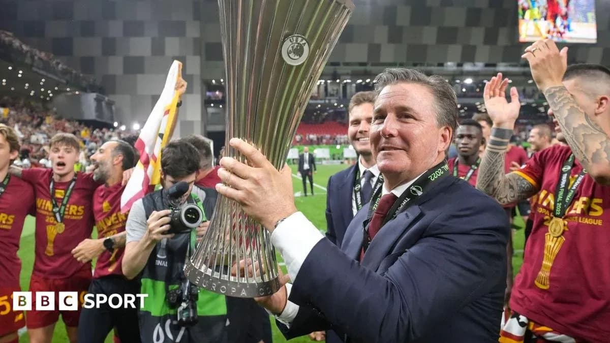 Coach celebrating with Europa League trophy and team