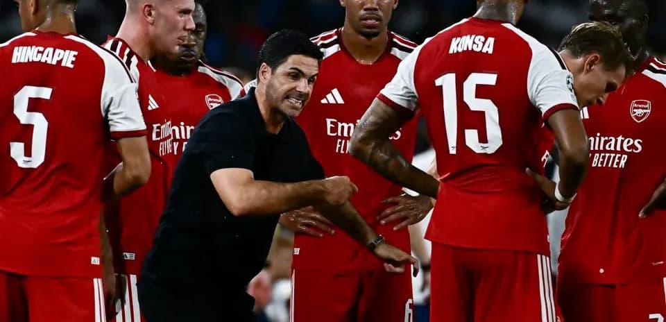 Arsenal players listening to manager during team huddle