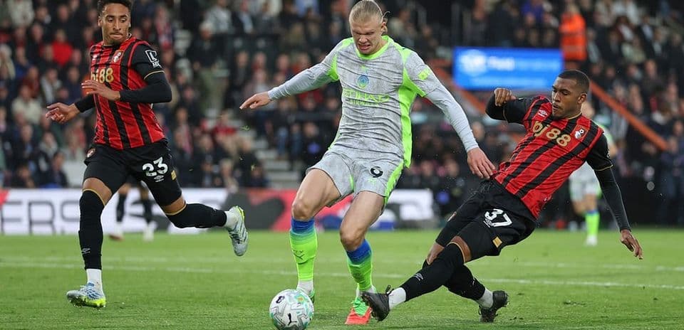Bournemouth players challenging Manchester City forward