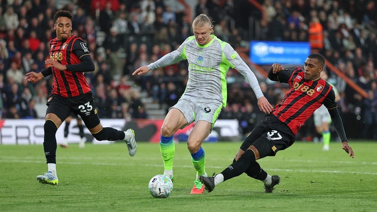 Bournemouth players challenging Manchester City forward