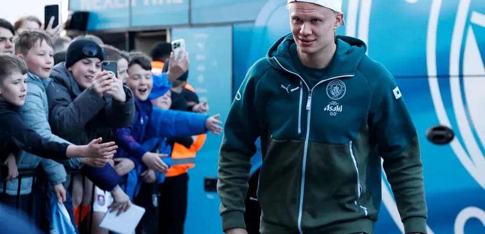 Player walking past fans outside team bus