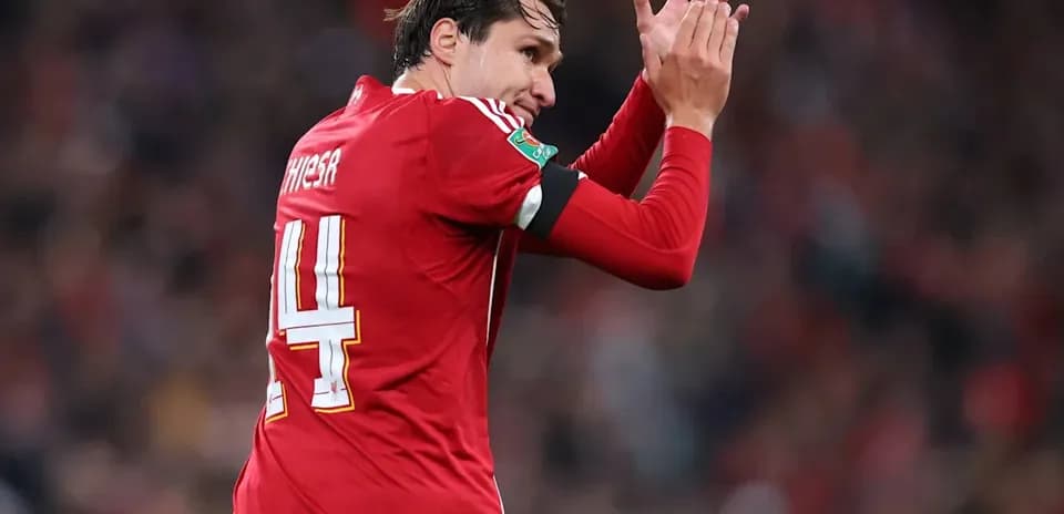 Player applauding fans while wearing red jersey