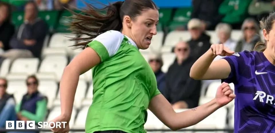Player in green jersey challenging opponent for the ball