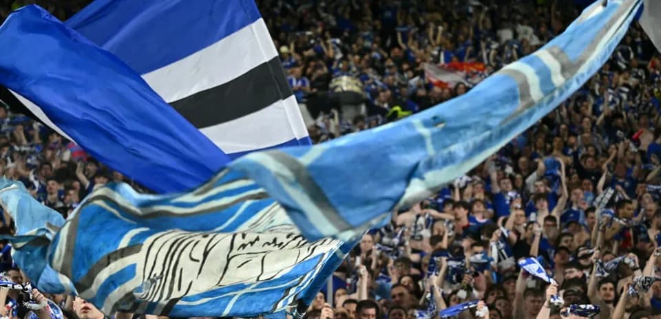 Fans waving flags and scarves in the stands