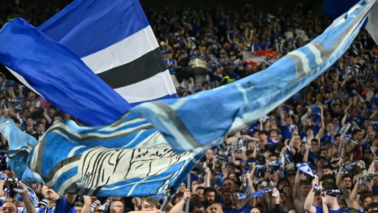 Fans waving flags and scarves in the stands