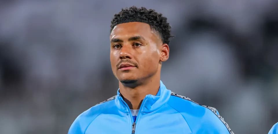 Player wearing blue training jacket on field