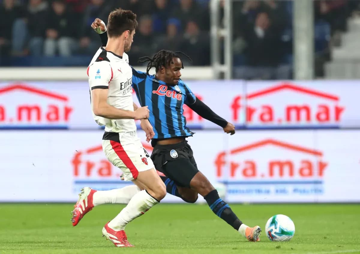AC Milan player tackling Atalanta opponent