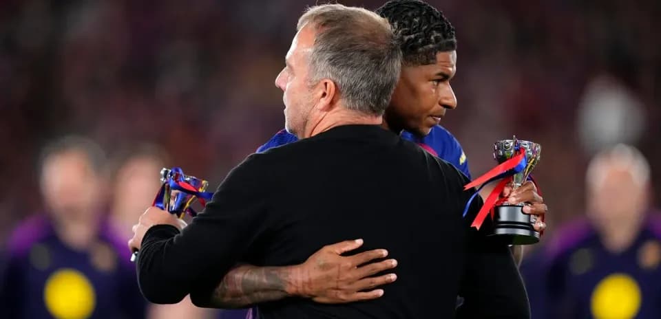 Player receiving trophy while embracing coach on field