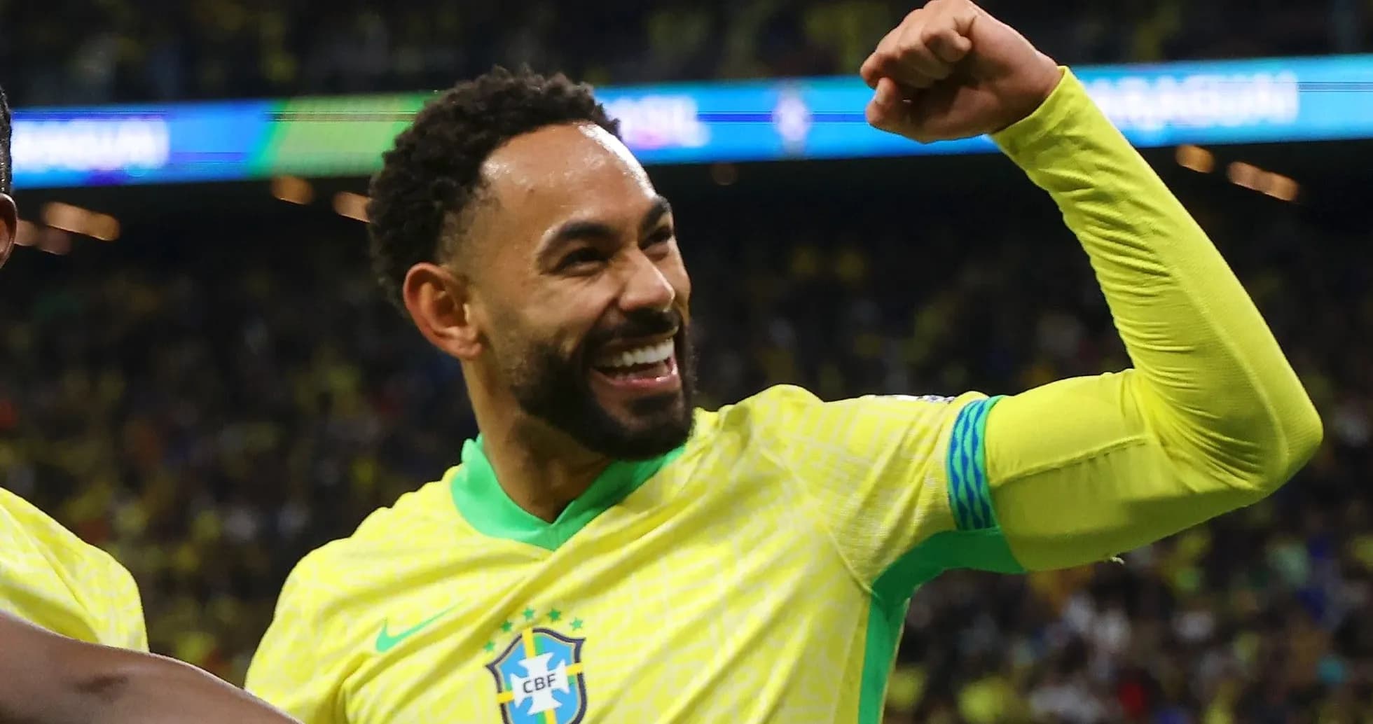 Player celebrating with raised fist in Brazil kit