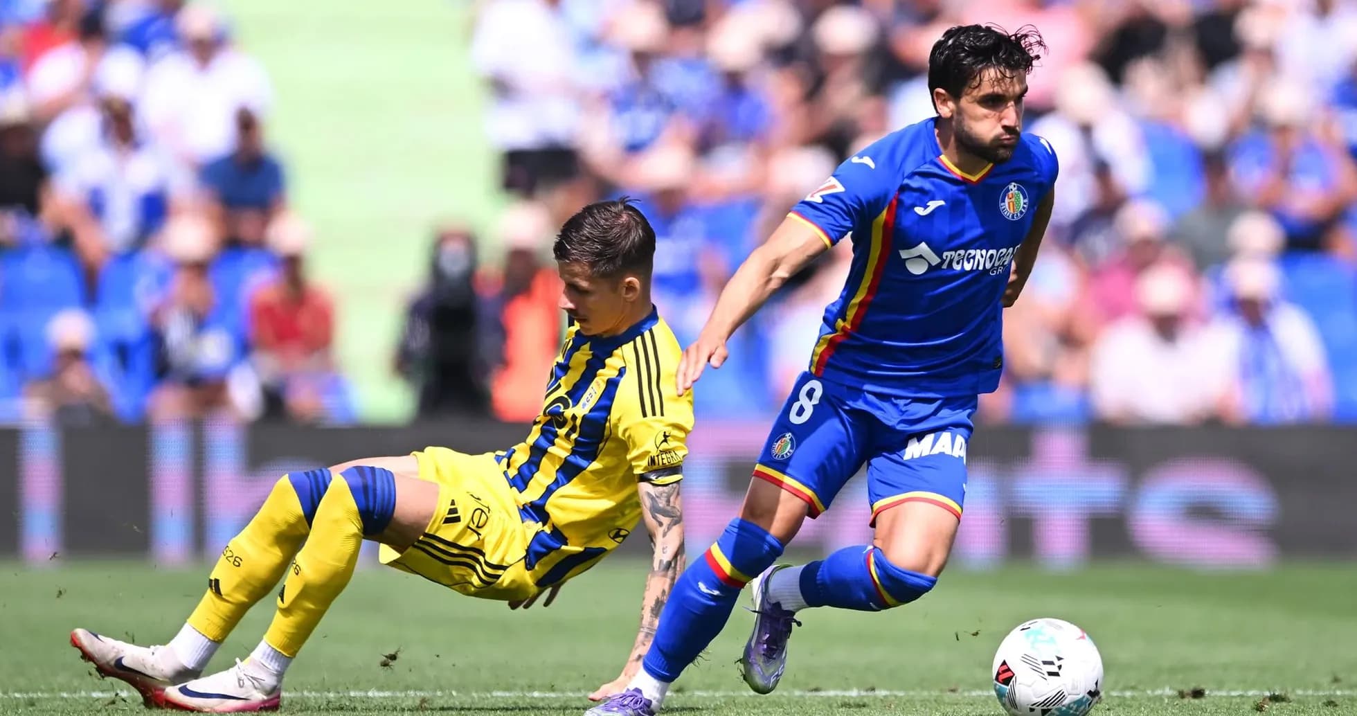 Player from Getafe dribbling past Oviedo defender