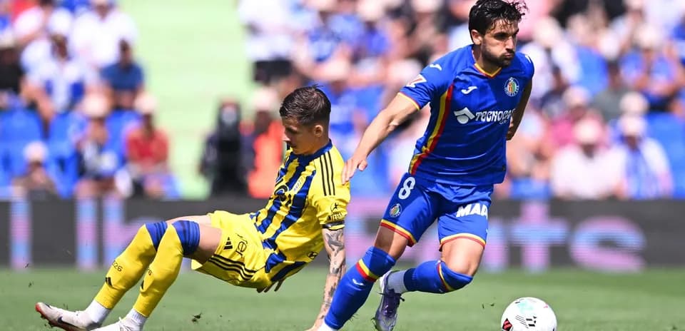 Player from Getafe dribbling past Oviedo defender