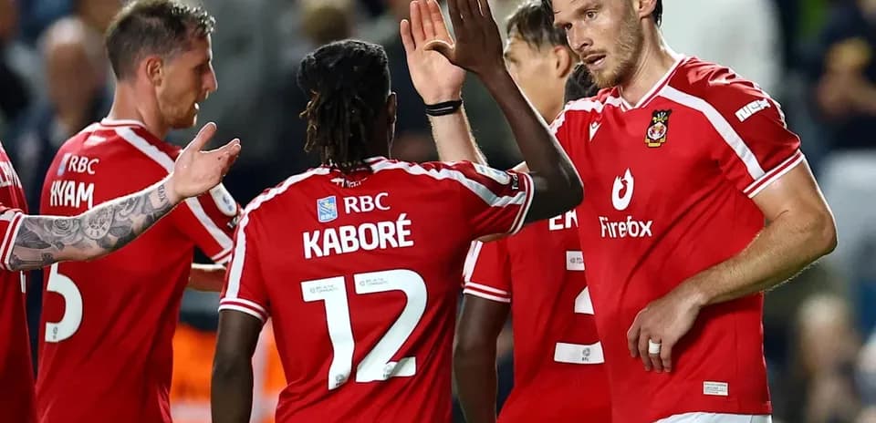 Players celebrating a goal in red team jerseys