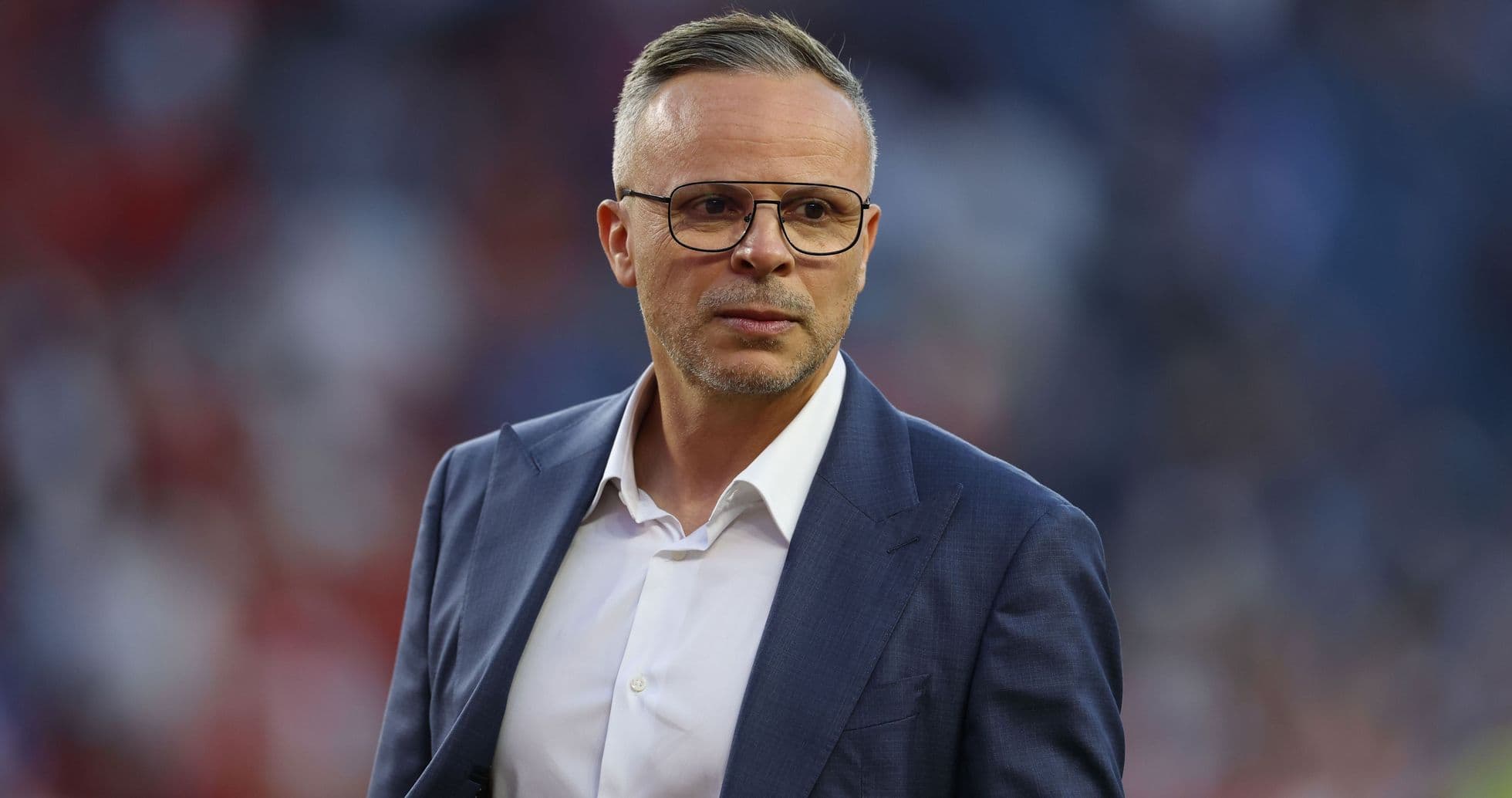 Man in suit looking serious on the sidelines