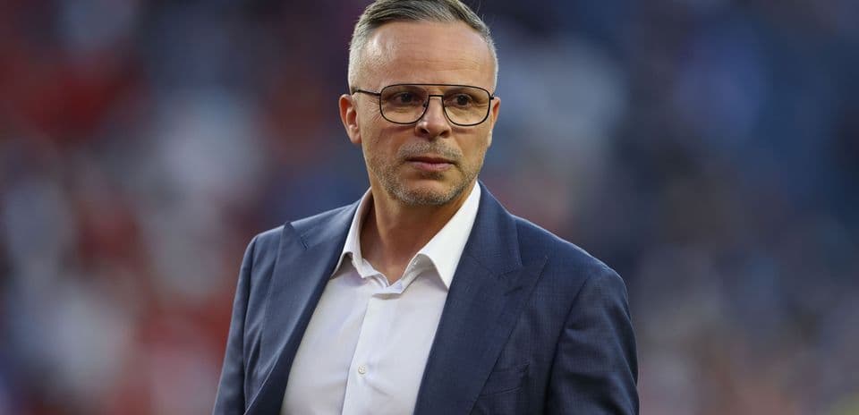 Man in suit looking serious on the sidelines