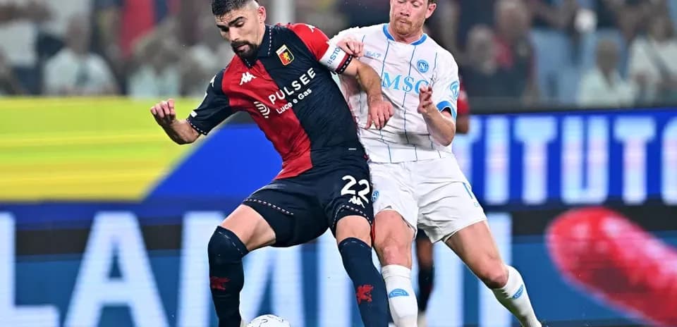 Genoa player tackling Napoli player during match