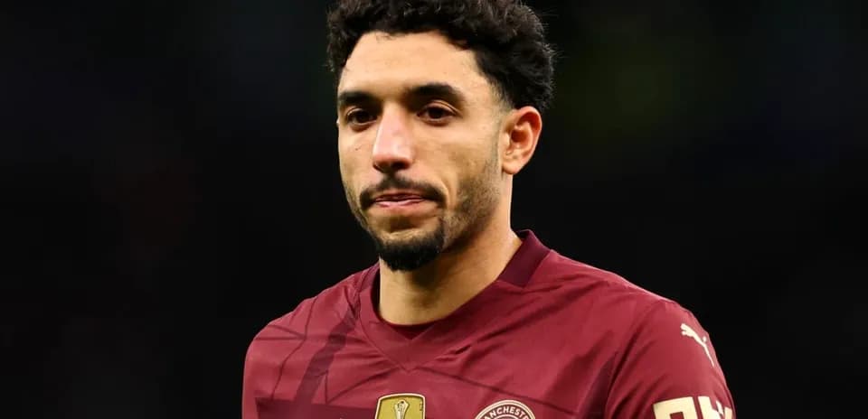 Player wearing maroon Manchester City jersey on field