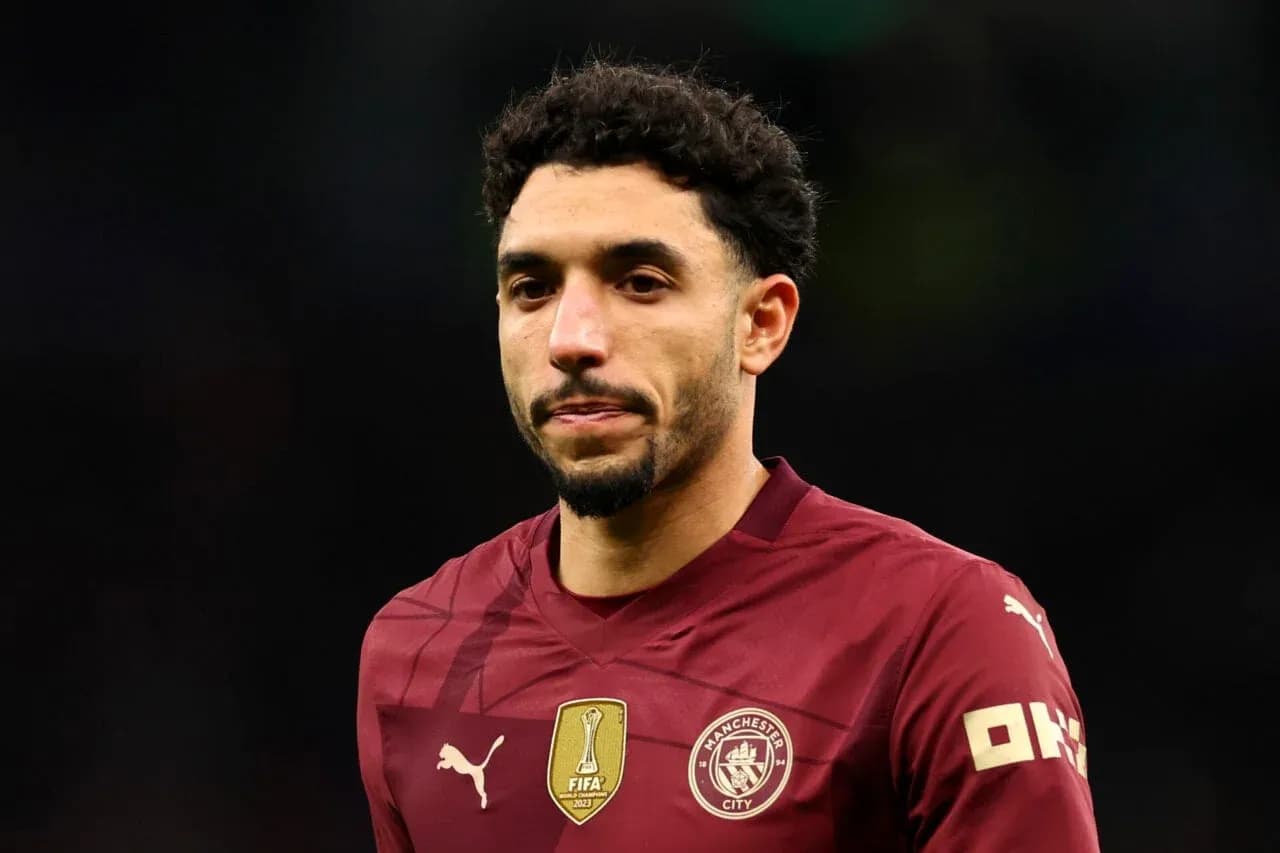 Player wearing maroon Manchester City jersey on field