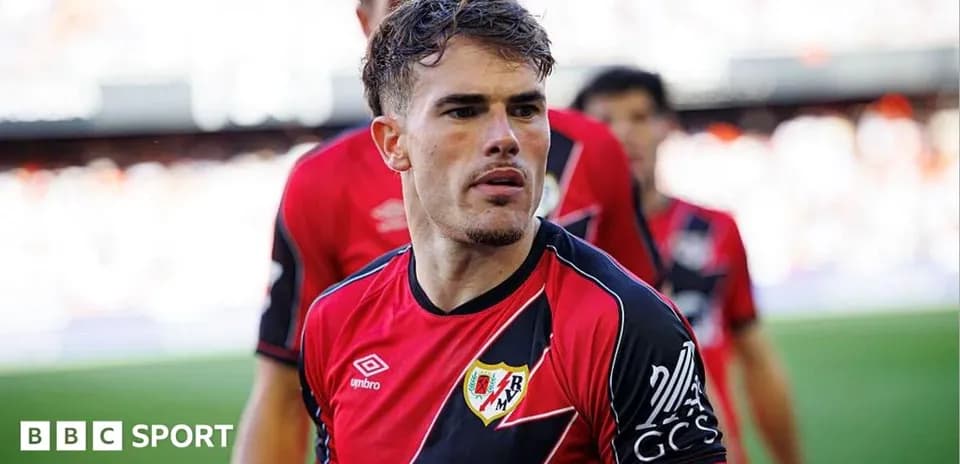 Player in red and black jersey during match warm-up
