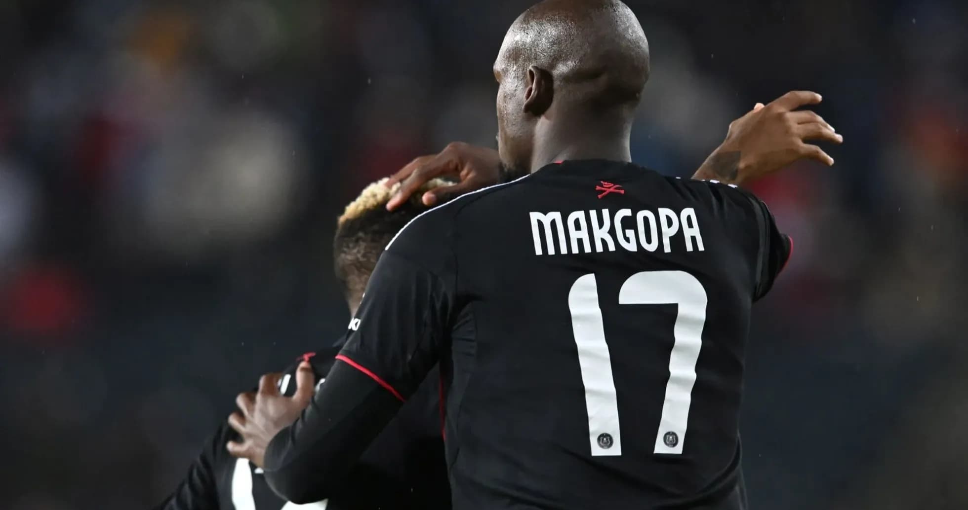 Players celebrating a goal in black jerseys