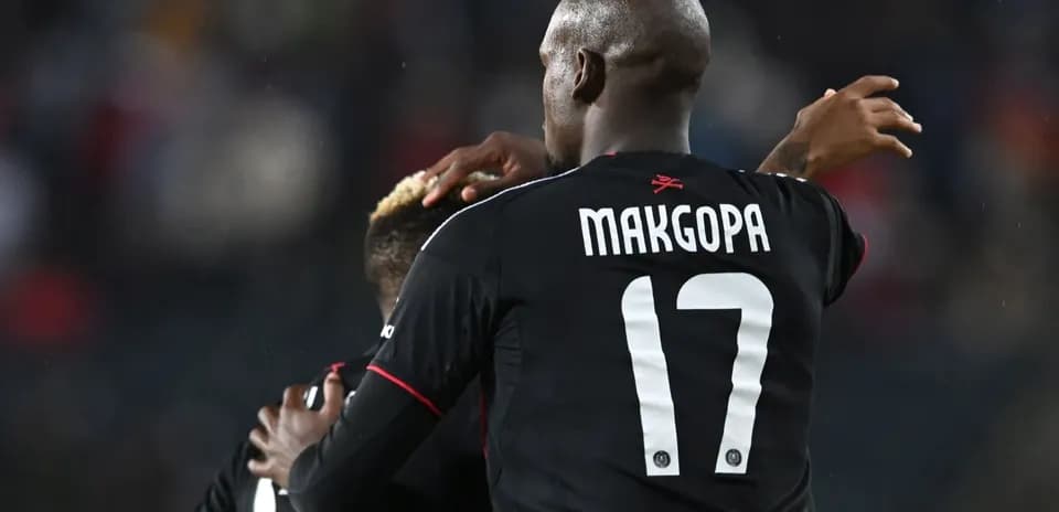 Players celebrating a goal in black jerseys