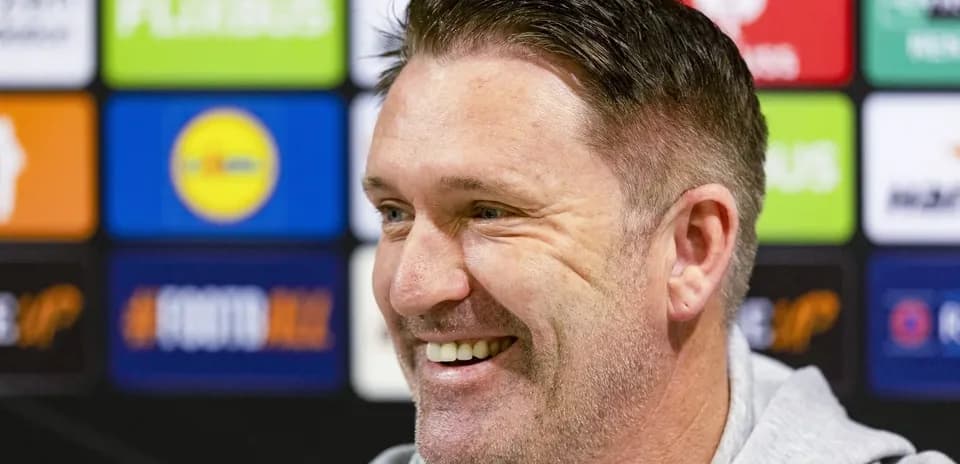 Man smiling during a press conference setup