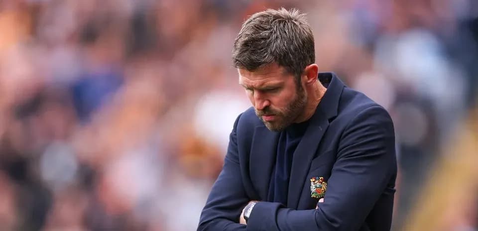 Coach with arms crossed during match on sidelines