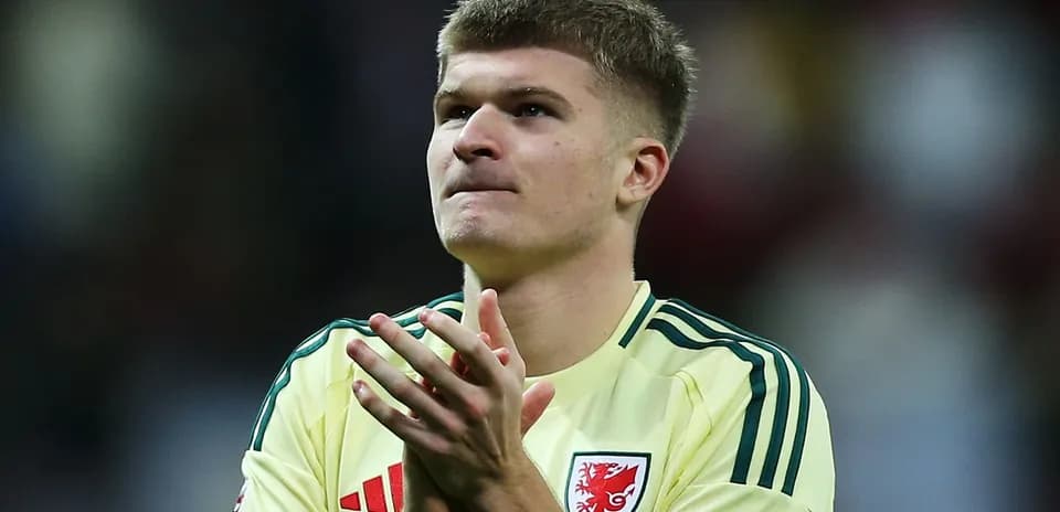 Player applauding fans after match wearing yellow kit