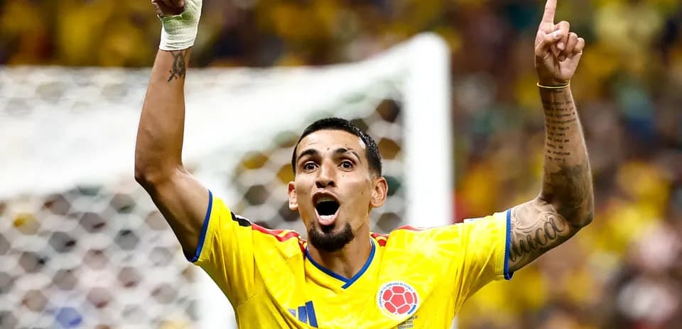 Player celebrating with raised arms in yellow jersey