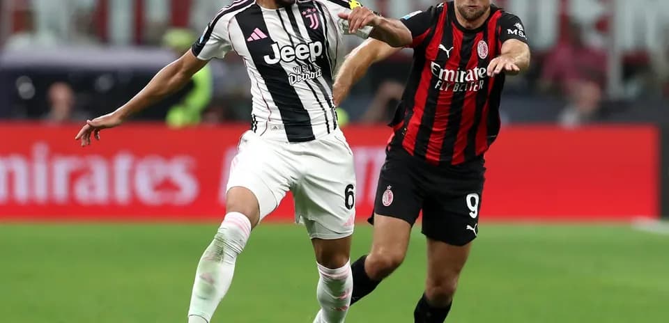 Juventus player battling with AC Milan opponent