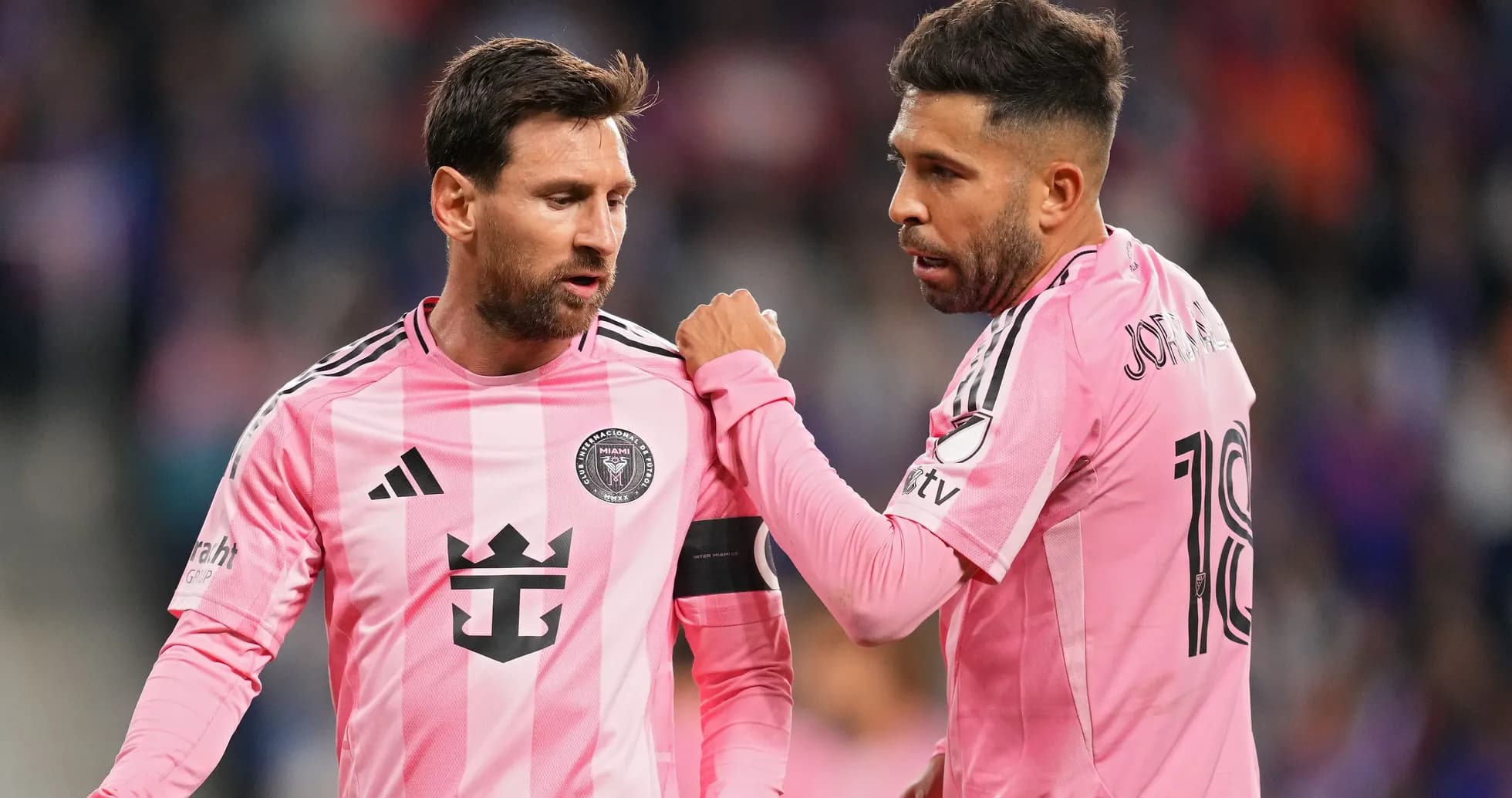 Two players discussing during a match in pink jerseys