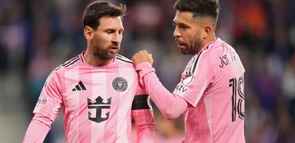 Two players discussing during a match in pink jerseys