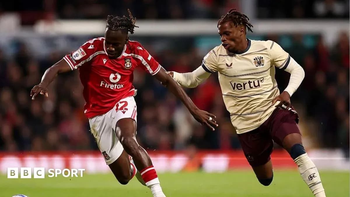 Player in red racing against opponent in cream jersey