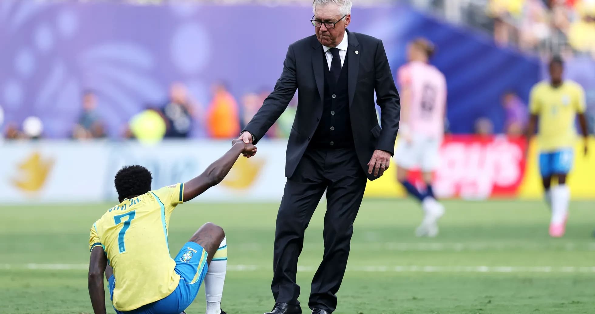 Coach assisting player on the field after injury