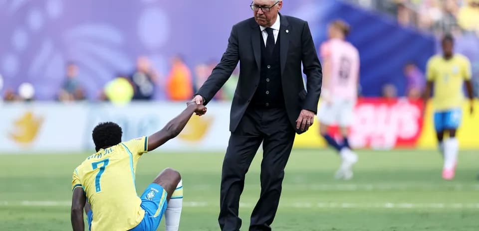 Coach assisting player on the field after injury