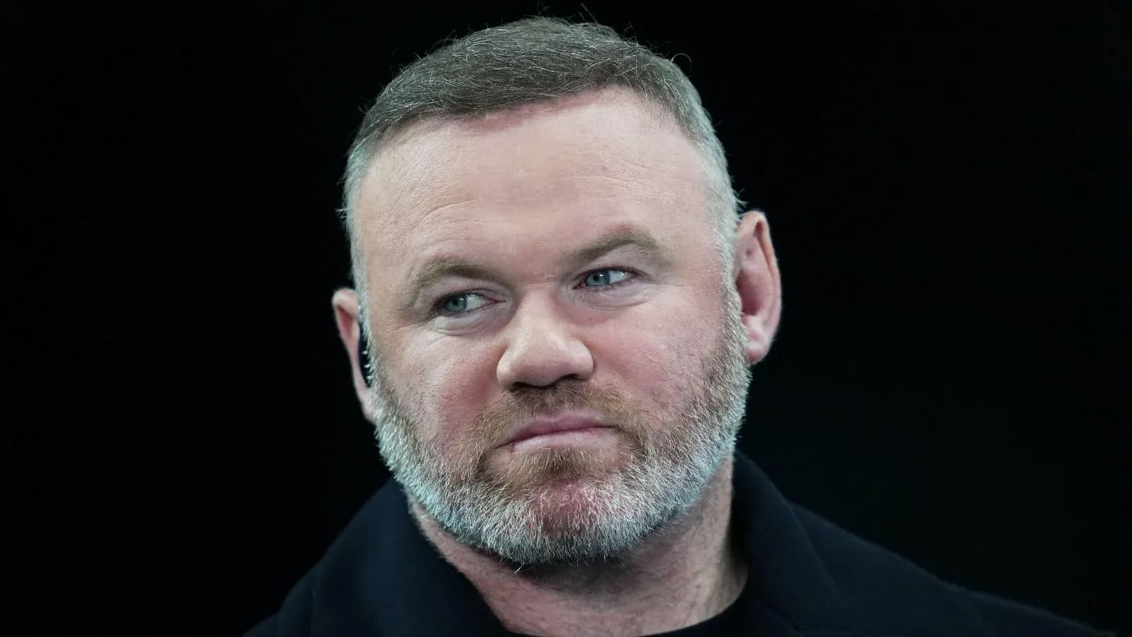 Man with short hair and beard looking forward