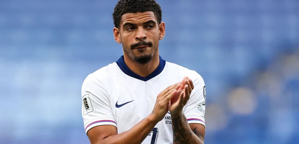 Player applauding in white team jersey on pitch
