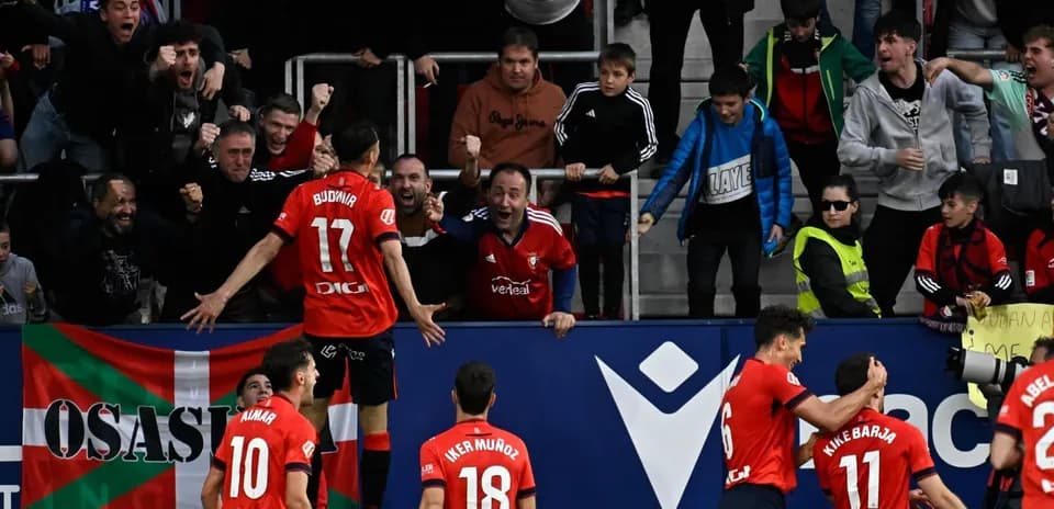 Osasuna players celebrating with fans after a goal