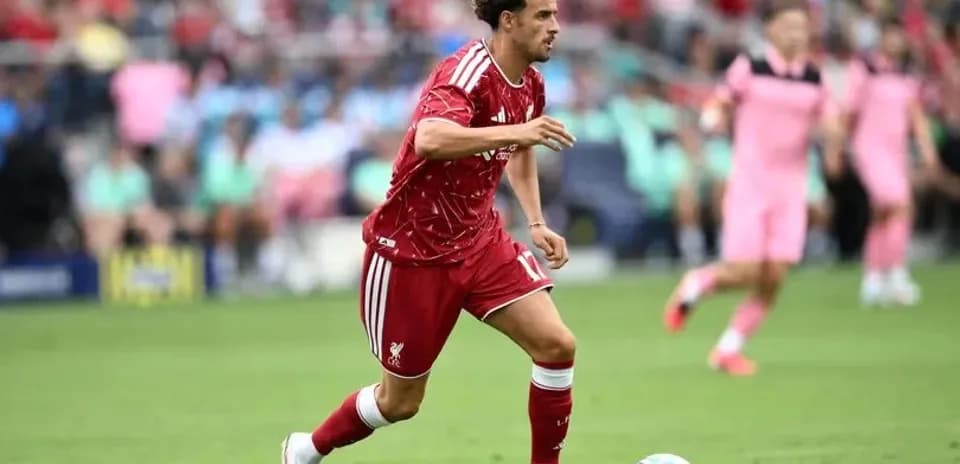 Player in red dribbling the ball on field