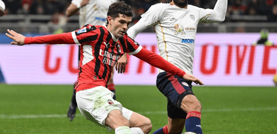 AC Milan player challenging Cagliari opponent for the ball