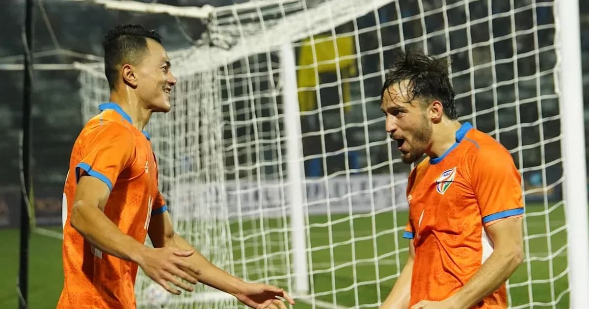 Two players celebrating a goal in orange jerseys