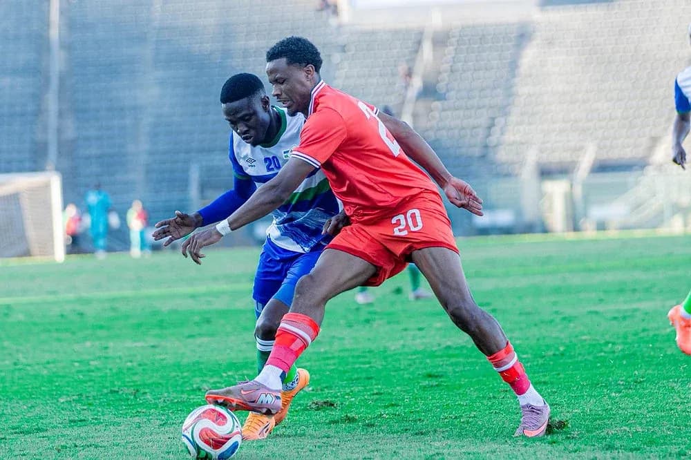 Two soccer players competing for the ball on field