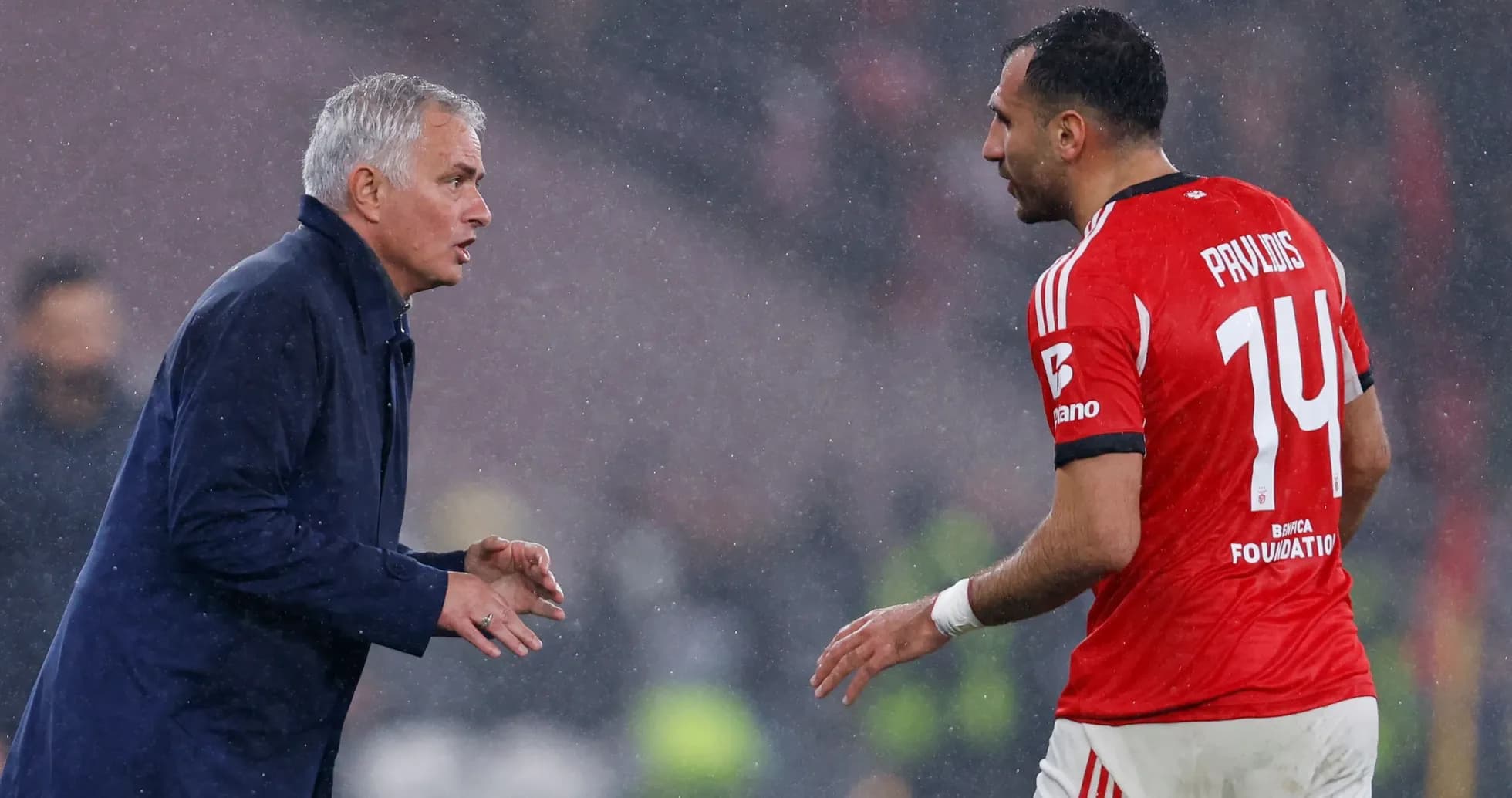 Manager instructing player during rainy match