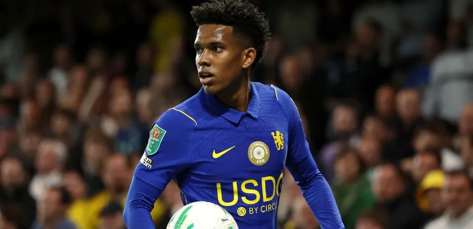 Player in blue jersey holding a football during match
