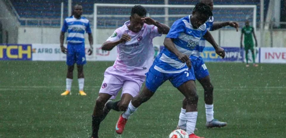 Enyimba player tackling Inter Lagos opponent in rain