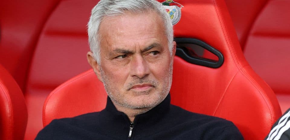 Manager seated on bench during a match