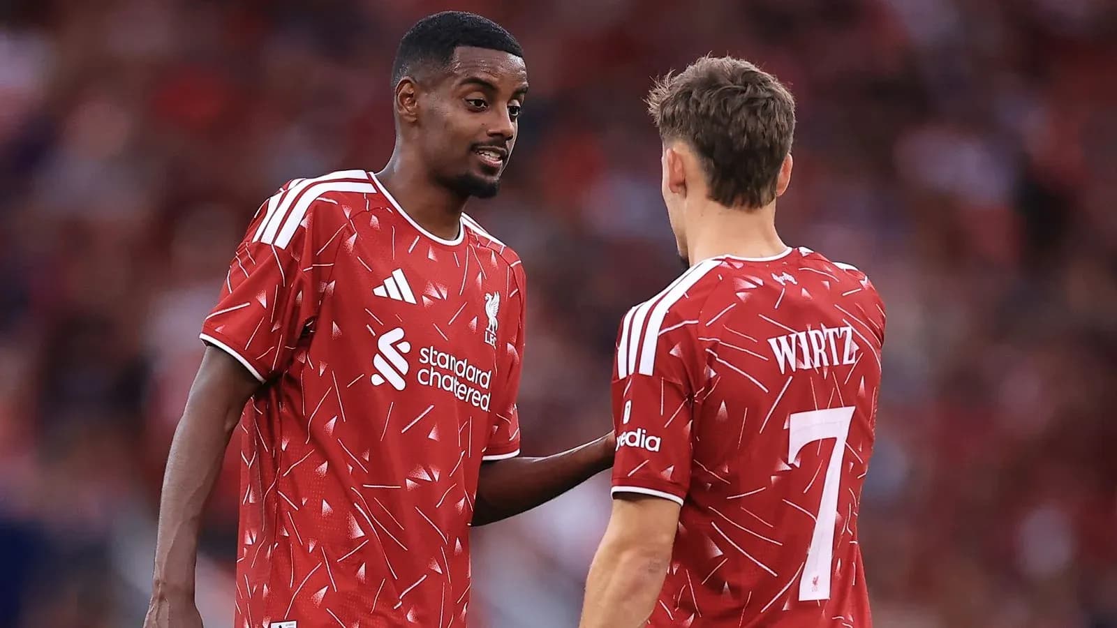 Two Liverpool players discussing on the field