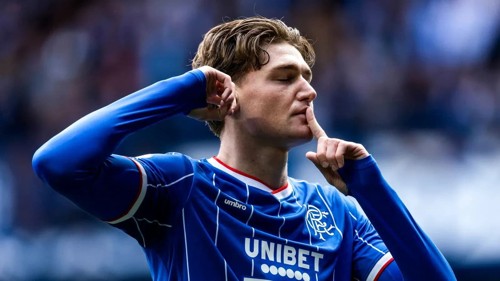 Player celebrating with finger on lips during match