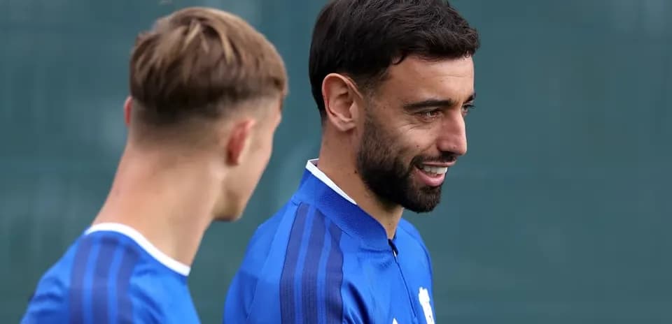 Two players in blue training kits talking outdoors