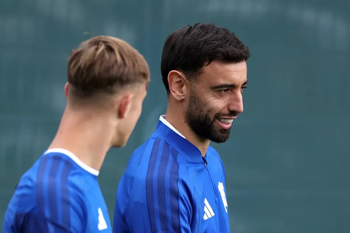 Two players in blue training kits talking outdoors