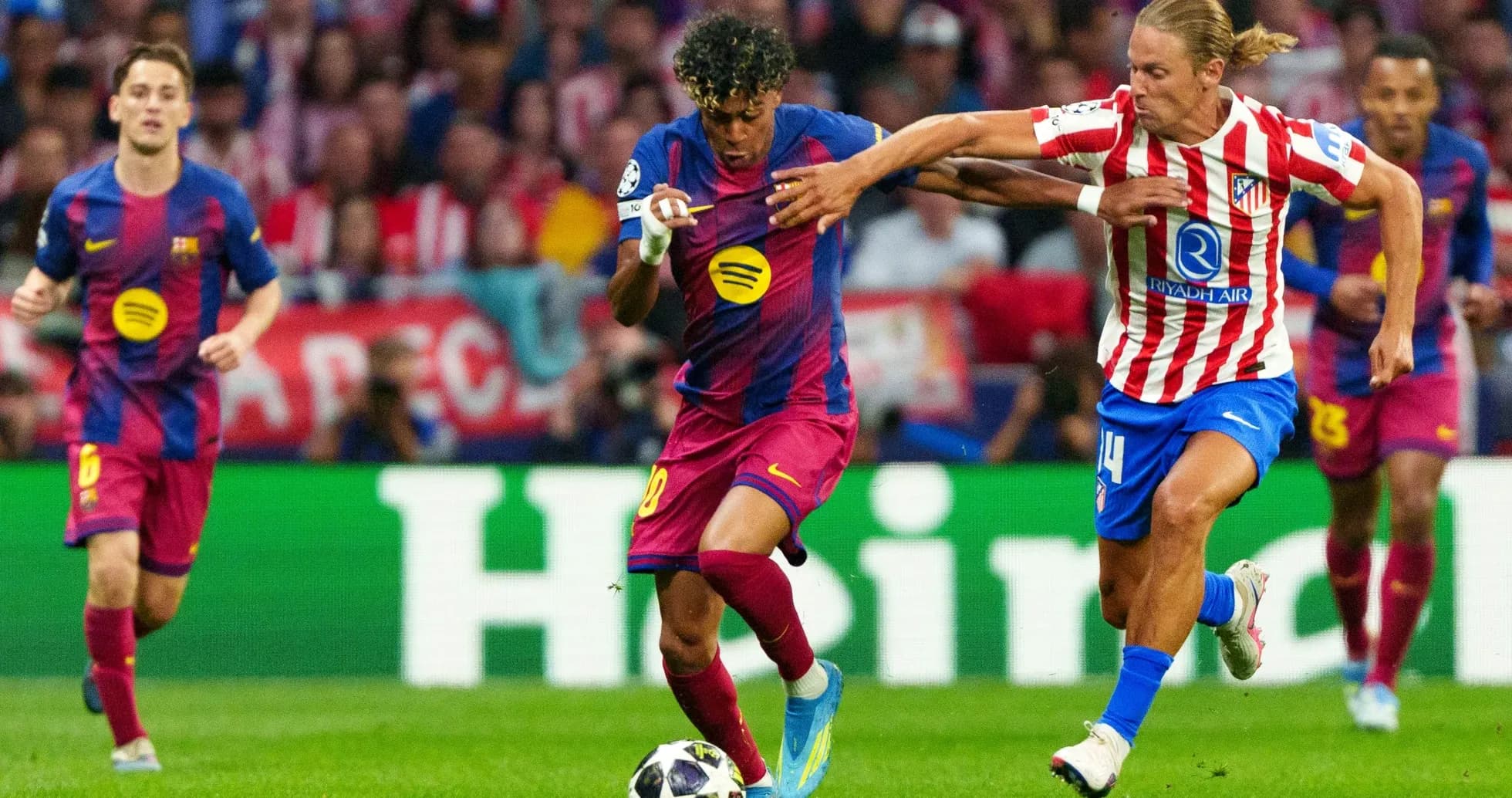 Barcelona player dribbling past Atletico Madrid defender
